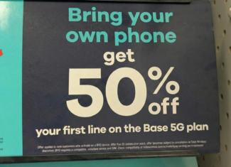 An in-store promotional sign from Target showcasing a Total Wireless offer. Large text on a dark blue background states: "Bring your own phone, get 50% off your first line on the Base 5G plan." Fine print mentions it is a new customer offer.