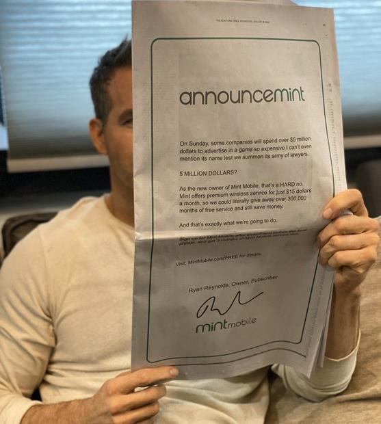 Actor Ryan Reynolds Holding NY Times Displaying Ad For Mint Mobile's Offer Of 3 Months Of Free Wireless Service
