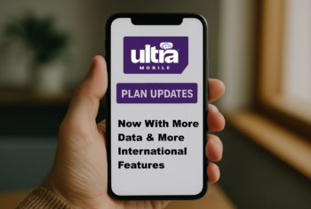 A realistic photo of a person’s hand holding a smartphone displaying an Ultra Mobile plan update. The phone screen shows the Ultra Mobile logo and text highlighting plan updates, more data, and international features. The background is softly blurred, featuring natural light from a window