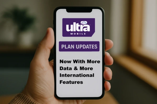 A realistic photo of a person’s hand holding a smartphone displaying an Ultra Mobile plan update. The phone screen shows the Ultra Mobile logo and text highlighting plan updates, more data, and international features. The background is softly blurred, featuring natural light from a window
