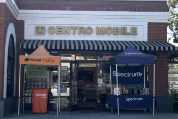 Photo of the front of a prepaid wireless dealer store in California. Boost Mobile and Spectrum tents out in front.